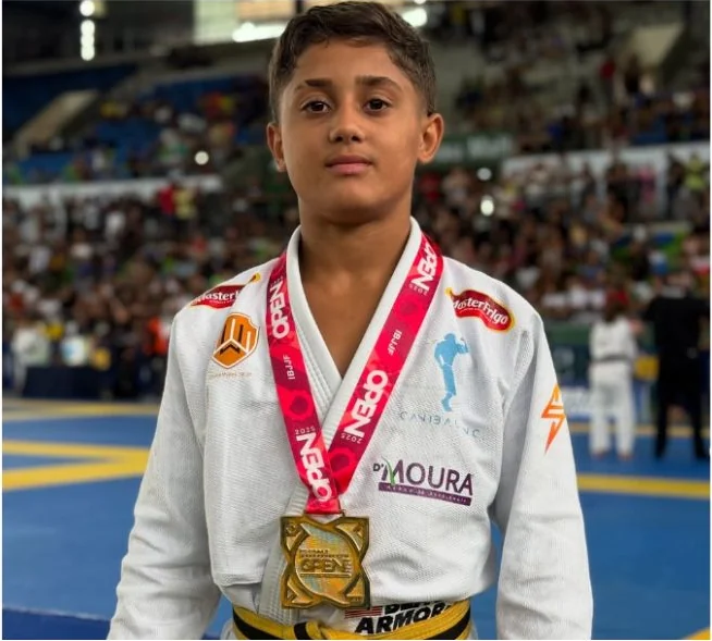 Daniel 220, campeão de jiu-jitsu e membro da Atleta Pro, com medalha de ouro e kimono cheio de patrocinadores